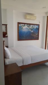 1 dormitorio con 2 camas y una foto en la pared en Oruwa Turtle Beach Villa en Kosgoda