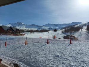 una pista de esquí cubierta de nieve con una estación de esquí en Appartement 6 personnes en Saint-François-Longchamp