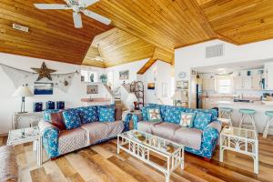 ein Wohnzimmer mit blauen Sofas und einer Holzdecke in der Unterkunft Sea Star #44-B in Buxton