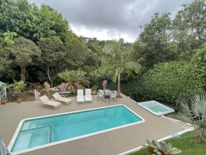 a swimming pool in a yard with a table and chairs at Oásis de Ibiúna in Ibiúna