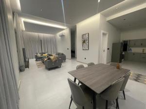 a dining room and living room with a table and chairs at شقه ذات سقف مرتفع لغير المدخنين في النرجس in Riyadh