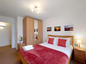 a bedroom with a large white bed with red pillows at London ExCeL Stays - Three Bed Serviced Apartment in London