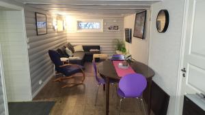 een woonkamer met een tafel en paarse stoelen bij Fin leilighet i stille og rolig område med gratis privat parkering! in Stavanger