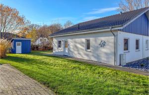 a white house with a blue roof and a yard at Ferienhaus 41 Altefähr in Altefähr