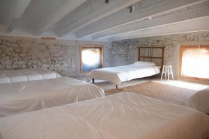a bedroom with three beds and a window at Can Traver de Besalú in Maia de Montcal +25 photos