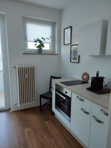 een keuken met witte kasten, een raam en een fornuis bij Maisonette Wohnung 110qm in Linz. in Linz