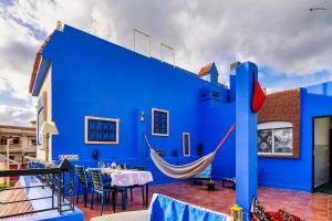 une maison bleue avec un hamac sur une terrasse dans l'établissement Ryad A&B Chaouen, à Chefchaouen
