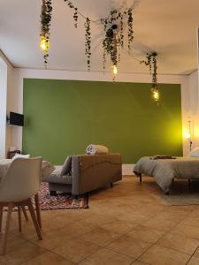 a living room with a green wall and a couch at La Sosta Domodossola in Domodossola