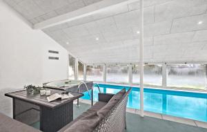 uma casa com uma piscina, um sofá e uma mesa em Amazing Home In Nrre Nebel With Indoor Swimming Pool em Nørre Nebel