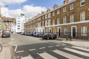 a street with cars parked in a row of buildings at Historic Joseph Conrad House in Heart of London! in London
