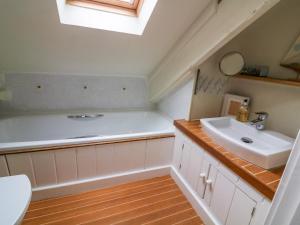 a bathroom with a sink and a bath tub at 1 The Old Brewhouse in Dartmouth +13 photos