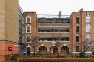 an old red brick building with a red door at Sleek Shoreditch Hideout - 2 Bed Gem with Balcony in Central London in London