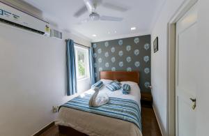 2 Bedroom Apartment in Resort on Candolim Beach في باغا: غرفة نوم مع بجعة جالسة على سرير