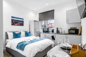 um quarto com uma cama grande e uma cozinha em Modern Studio Rooms in Wembley em Londres