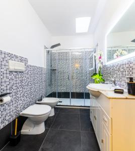 ein Badezimmer mit 2 WCs und einer Dusche in der Unterkunft Le Maschere B&B in Santa Teresa Gallura