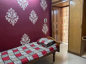 Mangala stay home (Malleshwaram) Ground Floor Apts في بانغالور: غرفة نوم بسرير وجدار ارجواني