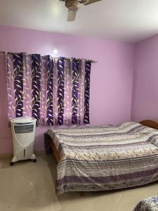 ein Schlafzimmer mit einem Bett und einer lila Wand in der Unterkunft Mangala stay home (Malleshwaram) Ground Floor Apts in Bangalore