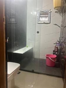 ein Badezimmer mit einer Dusche, einem WC und einem Eimer in der Unterkunft Mangala stay home (Malleshwaram) Ground Floor Apts in Bangalore