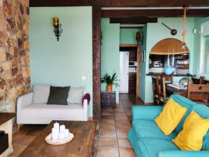 a living room with a blue couch and a kitchen at Casa Marvista - piscina, barbacoa y vistas al mar in Pineda de Mar