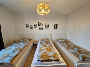 2 Betten in einem Zimmer mit Kronleuchter in der Unterkunft Ferienhaus in der Eifel Nähe Burg Satzvey, Phantasialand, Eifelwanderwege in Mechernich