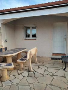 un patio con mesa y bancos frente a una casa en Maison 4/6 pers. Quartier calme en Aigues-Mortes