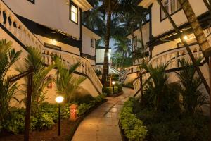 una pasarela junto a un edificio con palmeras en 2 Bedroom Apartment in Resort on Candolim Beach en Baga