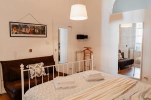een slaapkamer met een bed, een bank en een spiegel bij House of Happy Hours With TERRACE in Florence
