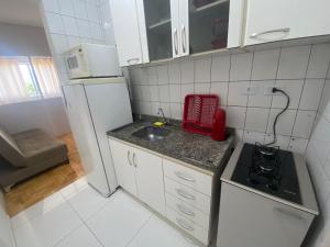 Una pequeña cocina con fregadero y refrigerador. en Studio ótima localização, en Foz do Iguaçu
