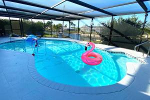 a swimming pool with a swan in the water at Waterfront Gulf Gateway: Pool/Dock/Grill/Gameroom in Fort Myers