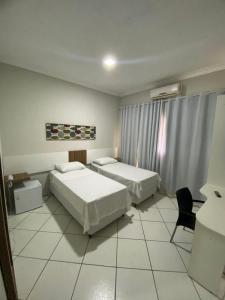 una habitación de hotel con dos camas y una silla en OSCAR BLUE MATO VERDE, en Mato Verde