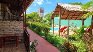 a backyard with a swimming pool and a house at Pousada Brasil - São Miguel do Gostoso in São Miguel do Gostoso
