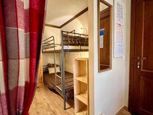レ・ズッシュにあるBellevue Studio Les Houchesの二段ベッドとドアが備わる小さな客室です。
