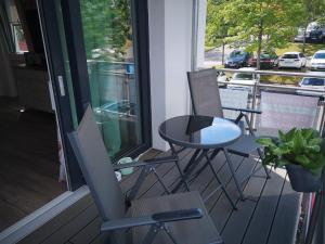 - une table et deux chaises sur une terrasse couverte avec une table dans l'établissement Die"53er" - Fit und Vital - a90094, à Grömitz