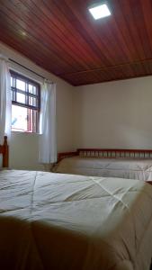 sypialnia z 2 łóżkami i oknem w obiekcie Casa boa vista w mieście Campos do Jordão