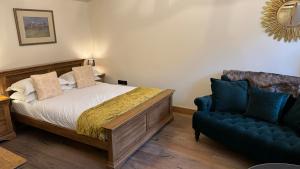een slaapkamer met een bed en een blauwe bank bij The Saddle Room in Middleham