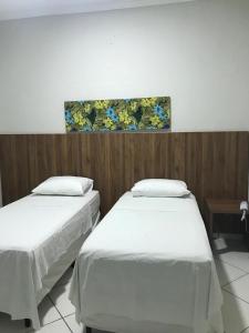 Dos camas en una habitación con un cuadro en la pared. en OSCAR BLUE MATO VERDE, en Mato Verde