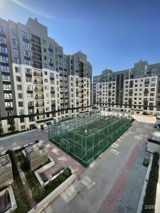 ein großes Gebäude mit einem Tennisplatz in der Mitte in der Unterkunft ЖК Коркем 4 in Astana