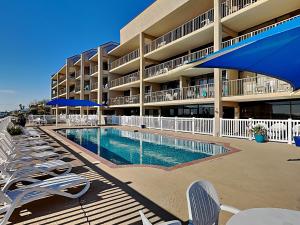 a hotel with a swimming pool and lounge chairs at LR 121 - Gone Coastal in Rockport