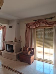 a living room with a fireplace and a large window at Serra e Mar Ferragudo in Ferragudo