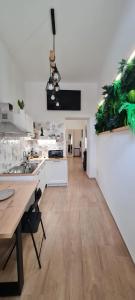 una cucina con banconi bianchi e pavimenti in legno di Viola Casa Vacanze a Ercolano