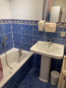 a blue tiled bathroom with a sink and a tub at LE CLOS D'HERBLAY Chambres d'Hôtes in Herblay +15 photos