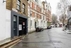 an empty street in a city with buildings and cars at Modern design 3BRs 2F house close to Victoria in London