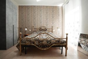 ein Schlafzimmer mit einem Bett vor einer Wand in der Unterkunft La Casa di Chiara 