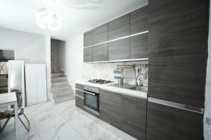 a kitchen with wooden cabinets and a sink and a stove at La Casa di Chiara in Coazzano