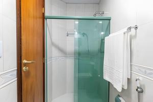 a glass shower door in a bathroom with towels at Vista Panoramica da Praia com 2qts, e vaga in Rio de Janeiro +38 photos