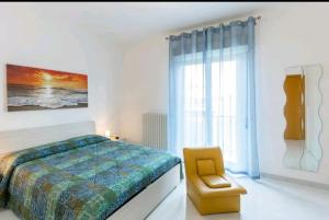 1 dormitorio con 1 cama, 1 silla y 1 ventana en SicilyRooms en Vittoria