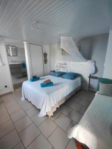 a bedroom with a large white bed with blue pillows at Case à Oculie Le Gosier in Le Gosier