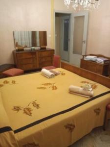 - une chambre avec un lit jaune et des serviettes dans l'établissement Room in BB - Stanza in affitto Giarre, à Giarre
