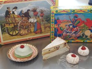 - une table avec quelques desserts et une boîte et un livre dans l'établissement Room in BB - Stanza in affitto Giarre, à Giarre