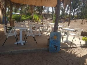 un grupo de mesas y sillas bajo una sombrilla en Poco Loco B&B, en Abémé